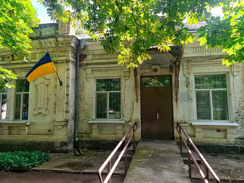 Стара громадська будівля з українським прапором